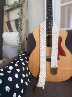 a guitar strap is attached to the back of an acoustic guitar in a living room