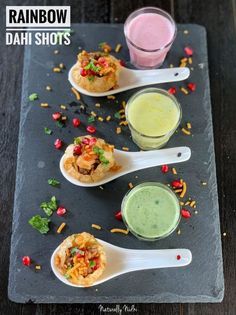 three spoons filled with different types of food on top of a slate platter