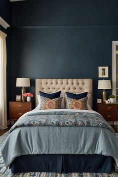 a bedroom with blue walls and white bedding, two lamps on either side of the bed