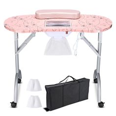 a pink ironing board sitting on top of a table with two bags next to it