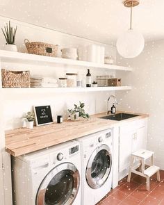 a washer and dryer sitting in a room next to a counter with pots on it