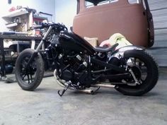 a black motorcycle parked in a garage next to a truck