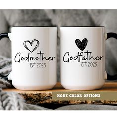 two personalized coffee mugs with hearts on them sitting on a wooden table next to a blanket