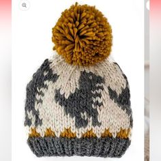 a knitted hat with an orange and gray pom - pom on top