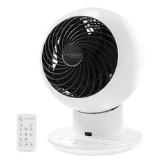 a white fan sitting on top of a table next to a remote control for the air conditioner