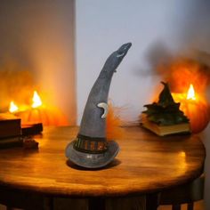 a wizard's hat sitting on top of a wooden table in front of candles