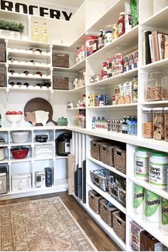 an organized pantry with white shelving and lots of food in baskets on the shelves