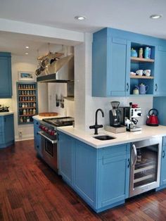 a kitchen with blue cabinets and wooden floors