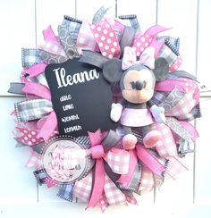 a minnie mouse wreath with a chalkboard on the front and pink ribbon around it