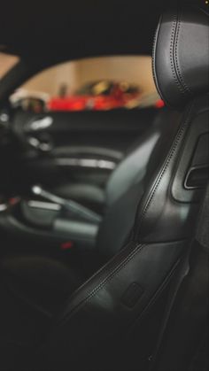 the interior of a car with black leather seats and steering wheel controls, including an automatic gear box