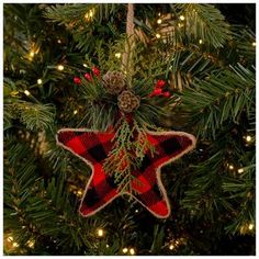 a red and black plaid star ornament hanging from a christmas tree