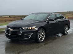 a black car is parked in the rain