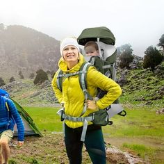 two people with backpacks standing next to a tent