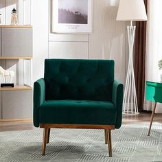 a green chair sitting on top of a rug in a living room next to a lamp