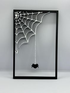 a spider web hanging from the side of a frame