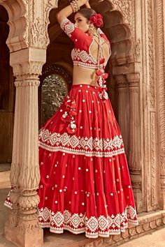 Red lehenga featuring embroidered intricate threadwork and mirror diamond patterns on tiers. Comes with a matching mirrorwork padded blouse and embroidered sheer dupatta. Components: 3 Pattern: Embroidered Type Of Work: Mirrorwork Neckline: Leaf Sleeve Type: Half Fabric: Lehenga and Blouse: Cotton Mulmul, Dupatta: Butterfly Net, Tulle, Lining: Shantoon Color: Red Other Details:  Lace borders Attached lining Lehenga side tasselled drawcord Blouse side zip closure Length (in inches):42 Weight(in k Mirrorwork Lehenga, Tiered Lehenga, Leaf Sleeve, Sheer Dupatta, Lehenga And Blouse, Butterfly Net, Blouse Cotton, Padded Blouse, Red Lehenga