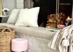 a living room filled with lots of pillows and blankets on top of a white couch