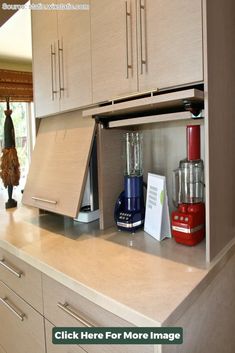 a kitchen counter top with an open cabinet on the bottom and various appliances in it