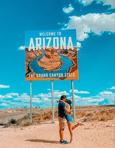 a woman standing in front of a sign for the grand canyon state park, arizona