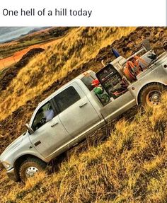 a pick up truck is parked on the side of a hill with an open hood