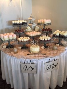 a table topped with lots of cupcakes and cakes