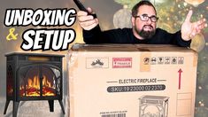 a man is standing in front of a box with an open fire place inside it