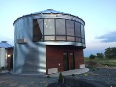 a round metal building sitting on top of a gravel field