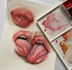 some watercolors are being used to paint the lips on paper and other items