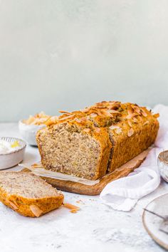 a loaf of bread sitting on top of a cutting board next to some other food