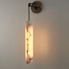 a wall light that is mounted on the side of a wall next to a white wall