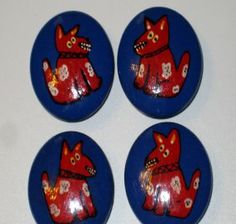 four red and blue buttons with an image of a cat on it's back