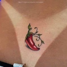 a woman's chest with a red pepper tattoo on it