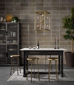 a dining table with three stools next to it and a wine rack in the background