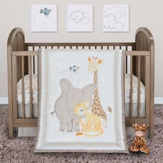 a baby crib with two pictures on the wall and a stuffed animal next to it