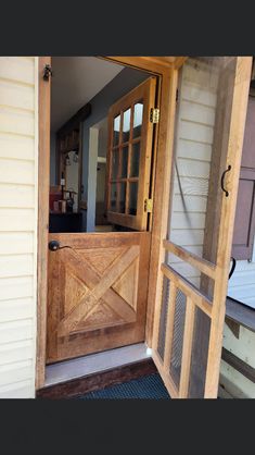 an open wooden door on the outside of a house with glass panels and wood trim