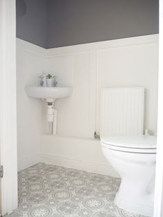 a white toilet sitting in a bathroom next to a sink