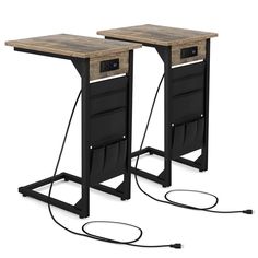 two black metal and wood tables with wires connected to the top, one is plugged in