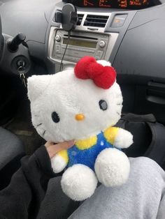 a hello kitty stuffed animal sitting in the driver's seat