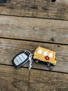 a car keychain with a crochet pattern on it sitting on top of a wooden table