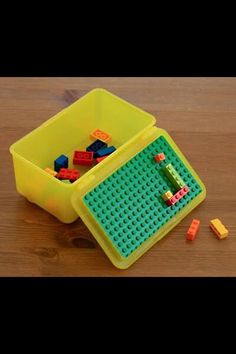 a yellow container filled with legos on top of a wooden table