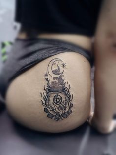 a woman's thigh with a tattoo on it and the moon above her belly