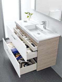 a bathroom vanity with drawers and a sink in the middle is open to reveal its contents