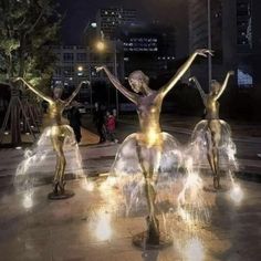 three statues in the middle of a fountain with water spouting from their arms