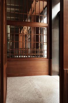 an empty room with wood paneling and white carpet