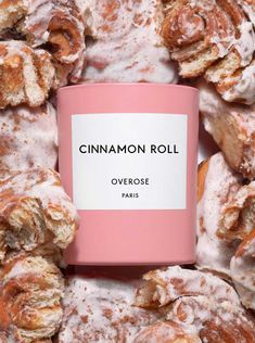 cinnamon roll covered in powdered sugar next to a pink coffee mug with the word, overosse paris on it