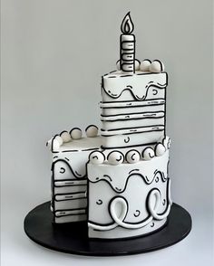 a three tiered cake is decorated with white icing and has a lit candle on top