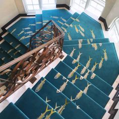 an aerial view of a stair case with fish painted on the floor and in the ceiling