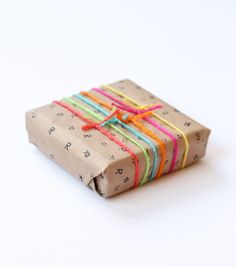 a wrapped gift box with colorful ribbons tied around it