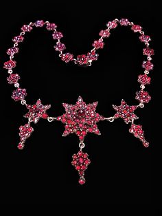 "This romantic piece transports us to the lushness of the Victorian era and dates back to the 19th century.  The necklace is all original, and was designed with genuine Bohemian garnets. The term \"Bohemian garnets\" is an established trade name for dark red pyrope crystals originating from the Czech Republic.  All garnets are set in closed back metal featuring a motif of all around garnet star clusters made of gilded brass; this method is sometimes referred to as 'garnet gold'. During the Victorian era garnets were one of the most popular stones to be used in jewelry production.  Bohemian garnets have been used in jewelry since the 5th century. It has been a gemstone for kings, nobility and liturgical objects throughout the Medieval period and beyond. From the 19th century onwards, it has All The Best Wishes, Star Clusters, Jewelry Star, Victorian Necklace, Garnet And Gold, Medieval Period, Garnet Necklace, Necklace Wedding, Bohemian Necklace