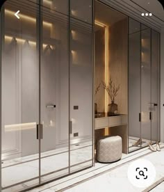 the interior of a modern bathroom with mirrored walls and marble flooring is lit by recessed lighting